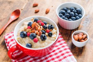 Veganer Porridge mit gesunden Beeren in einer Tasse